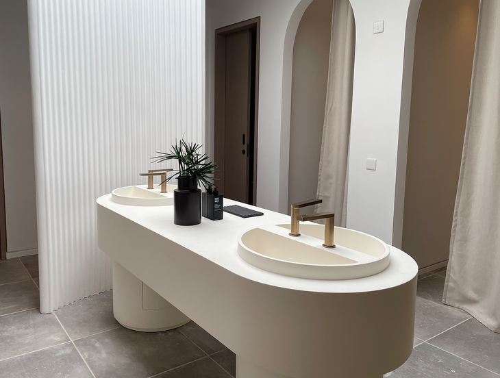 Boutique hotel bathroom with a custom solid surface countertop and unique basin design
