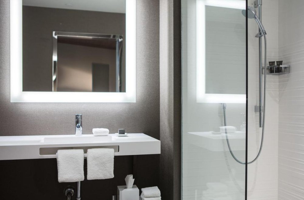 hotel bathroom sink with towel rack and led mirror